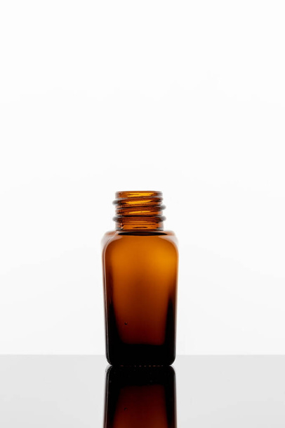 Láhev esenciálního oleje na jasném pozadí, s kopírovacím prostorem - Fotografie, Obrázek