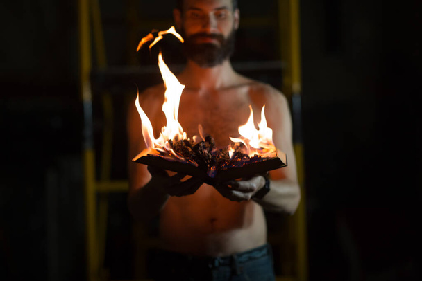 Muž drží v rukou hořící knihu. - Fotografie, Obrázek