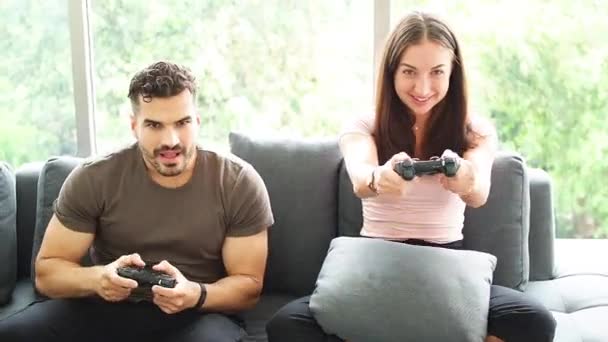 Boldog fiatalok játszanak otthon videojátékokkal Covid-19-es szituációban. Maradj otthon koncepció, Vicces fiatal pár nyerő videojáték, szórakozás. - Felvétel, videó