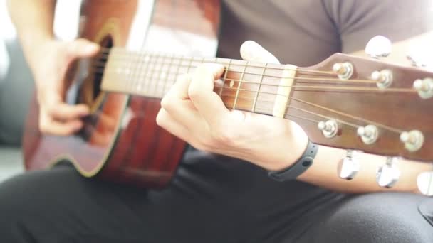 Man playing love songs for lover. concept celebrating, Joyful guy is playing the guitar singing having fun on sofa at home. Music and happy young people concept. - Footage, Video
