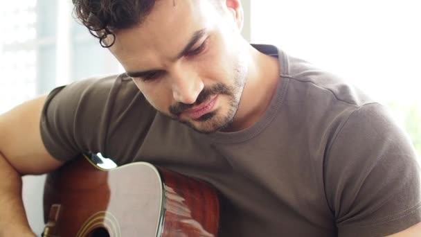 Man playing love songs for lover. concept celebrating, Joyful guy is playing the guitar singing having fun on sofa at home. Music and happy young people concept. - Video