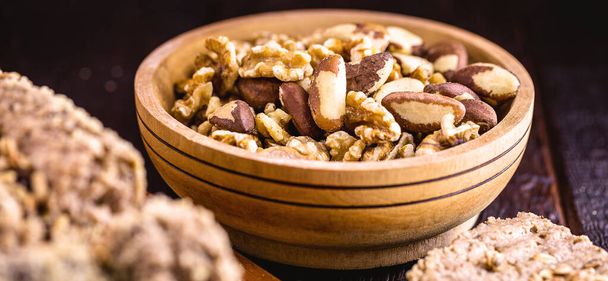 ořechy, mandle a brazilské ořechy mleté v dřevěných mísách. Zdravé a veganské složky potravin. - Fotografie, Obrázek