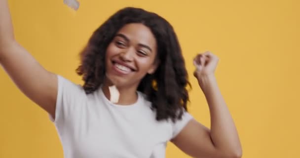 Excited african american girl dancing under rain of confetti - Video, Çekim