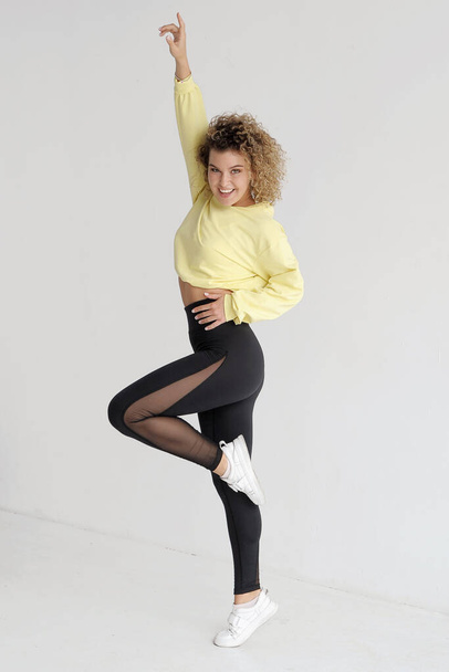 Pretty curly hair dancer on light background.  - Foto, immagini