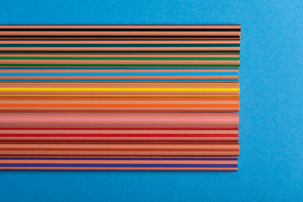 Rainbow pencils background over blue meaning diversity in education - Photo, Image