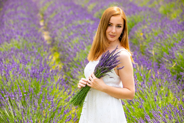 Frau spaziert mit Blumenstrauß in Lavendelfeld in Tschechien - Foto, Bild