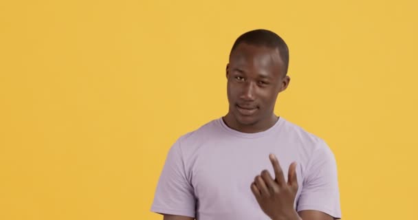 Figlarny czarny facet wzywa cię, gestykulując, aby spotkać się w prywatności - Materiał filmowy, wideo