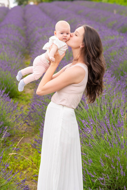 Mother walks with her little daugher holding a bouquet of lavander in Czech republic - Photo, Image