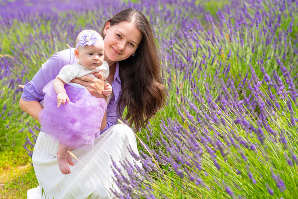 母はチェコ共和国でラベンダーの花束を持っている彼女の小さな娘と一緒に歩きます - 写真・画像