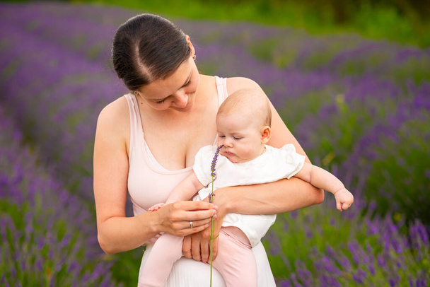 Mutter geht mit ihrer kleinen Tochter mit einem Lavendelstrauß in Tschechien - Foto, Bild