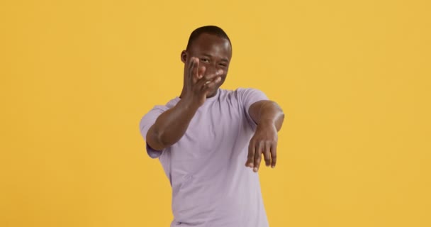 Playful black guy shooting to camera with hands and smiling - Imágenes, Vídeo