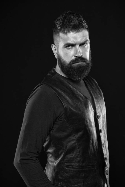 Man confident and brutal style black background. Barbershop concept. Grow mustache. Fashion model. Strict mature face. Facial hair. Male face. Handsome face. Man with beard in black leather clothes - Photo, Image