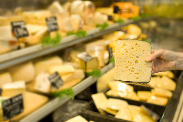 Жінка вибирає сир у супермаркеті. Концепція здорової їжі, біо, вегетаріанська, дієта
. - Фото, зображення