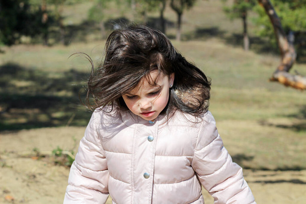 Szoros portré dühös fehér lány hosszú haj emelkedik felfelé homályos természetes háttér - Fotó, kép