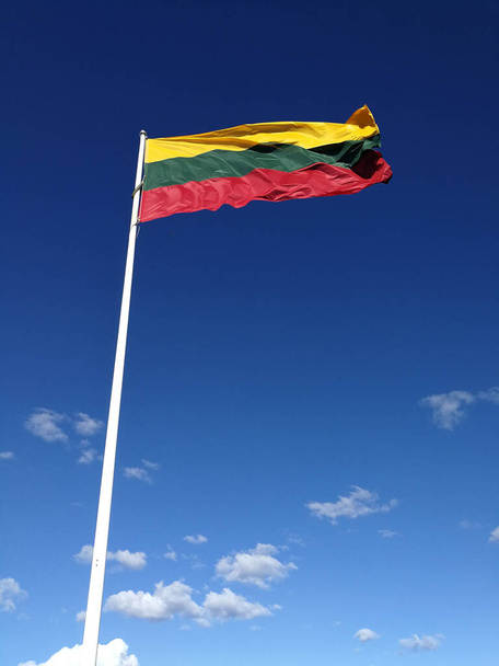 Bandeira da Lituânia tricolor na frente do céu azul. Conceito de orgulho e liberdade
 - Foto, Imagem
