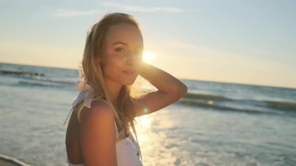 Jovem mulher gentil desfrutando do pôr do sol perto do mar
 - Filmagem, Vídeo