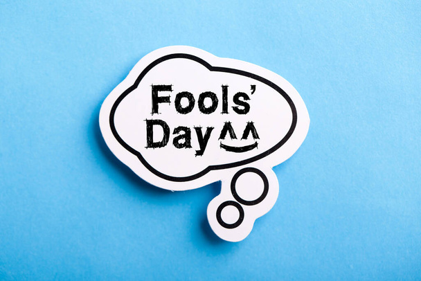Happy April Fools' Day speech bubble isolated on blue background. - Фото, зображення