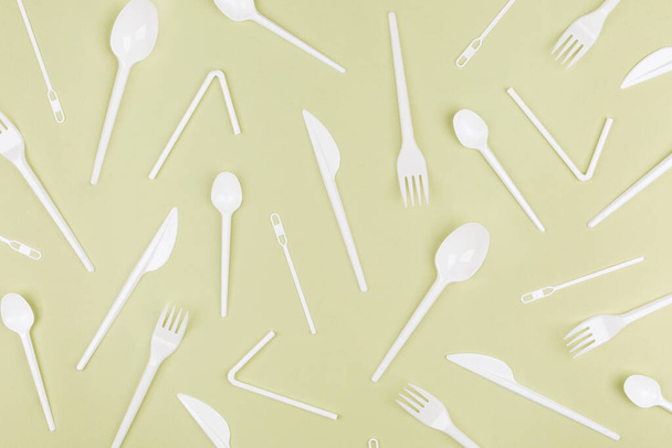Food plastic packaging on green background. Concept of Recycling plastic and ecology. Plastic waste. Collection of various cutlery. Flat lay, top view - Foto, Imagem