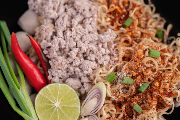 Mama with minced pork in a pan, along with lime, chilies, and meatballs. - Photo, Image