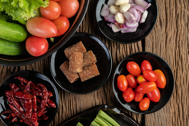 Pálmacukor, vöröshagyma, szárított paprika, paradicsom, uborka, udvari hosszú bab és saláta tálban. - Fotó, kép