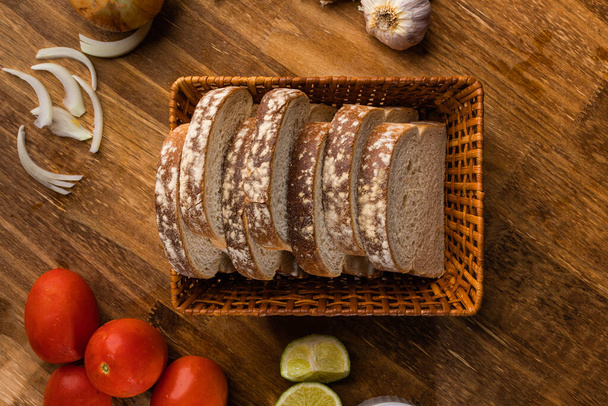 Krájený bílý chléb s pšeničnou moukou na dřevěném stole. - Fotografie, Obrázek