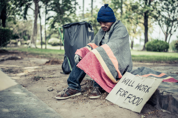 乞食、布に包まれた後、帽子をかぶって道路の横に座って. - 写真・画像