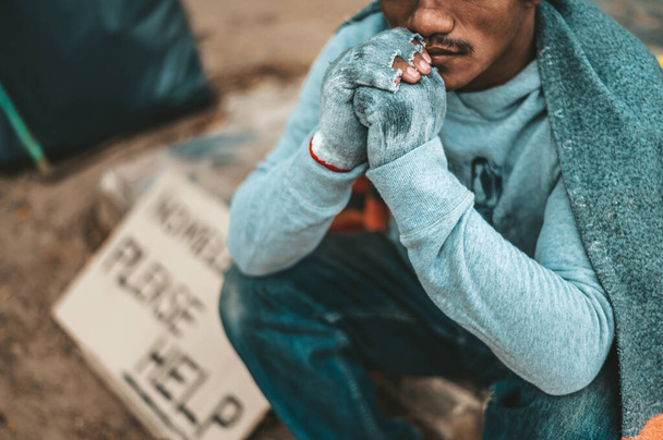 een man zit bedelaars met daklozen gelieve te helpen bericht. Selectieve focus. - Foto, afbeelding