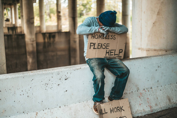 Los mendigos se sientan en las barreras con las personas sin hogar Por favor ayuda mensajes
. - Foto, Imagen