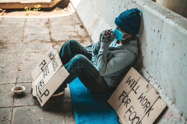 De bedelaars zaten naast de straat met een dakloze boodschap. Gelieve te helpen en te werken met voedsel. - Foto, afbeelding