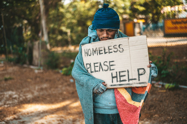 Mendigos de pie en la calle con mensajes para personas sin hogar por favor ayuda
. - Foto, imagen