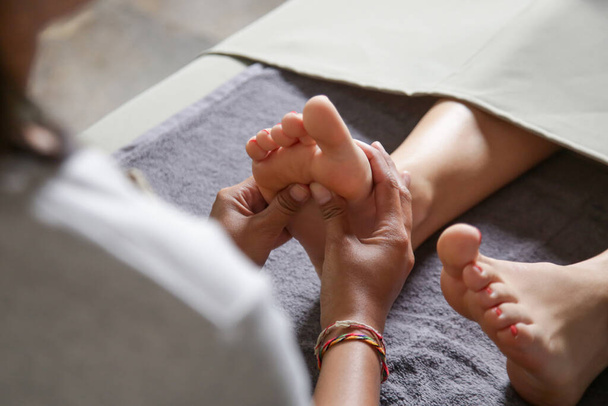 Young woman having feet massage in beauty salon, close up view - Фото, зображення