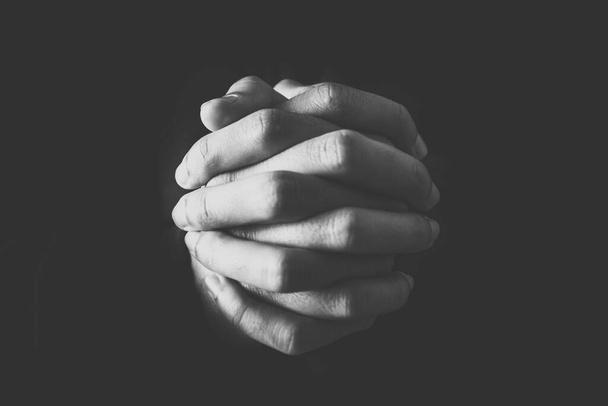 Christian faith towards God concept, Asian man christians worship and pray in church. Praying in dark black background. - Photo, image