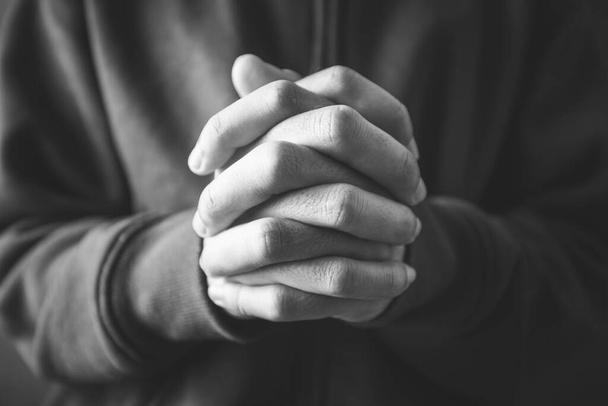 Christian faith towards God concept, Asian man christians worship and pray in church. Praying in dark black background. - Φωτογραφία, εικόνα