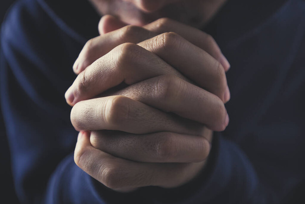 Christian faith towards God concept, Asian man christians worship and pray in church. Praying in dark black background. - Φωτογραφία, εικόνα