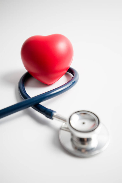 Red heart with stethoscope on white background, heart health, health insurance concept, world health day. - Foto, Bild