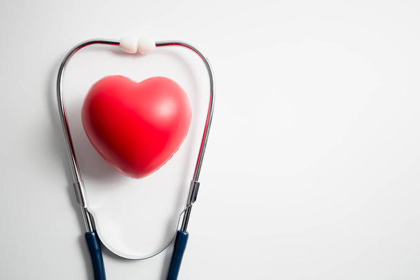 Red heart with stethoscope on white background, heart health, health insurance concept, world health day. - Foto, Bild