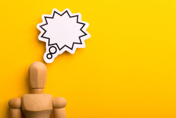 Thinking concept with blank speech bubble and wooden man on yellow background with copy space. - Fotoğraf, Görsel