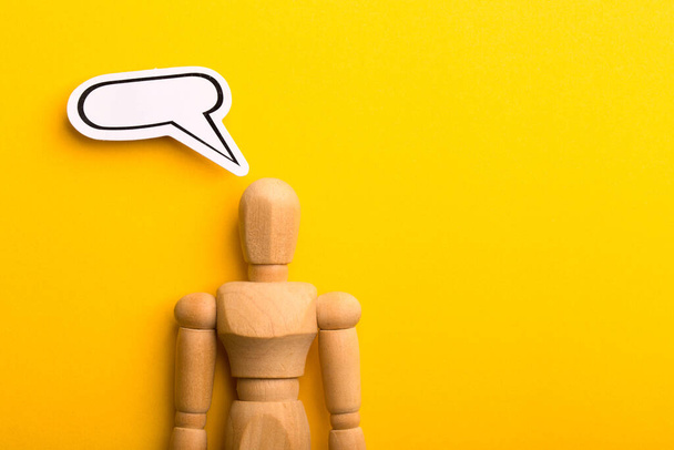 Thinking concept with blank speech bubble and wooden man on yellow background with copy space. - Fotoğraf, Görsel