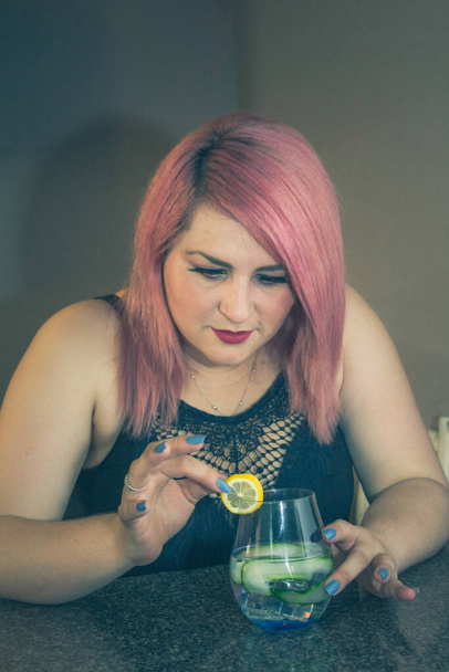 bartender woman preparing refreshing cocktail with cucumber, lemon and vodka - Foto, afbeelding