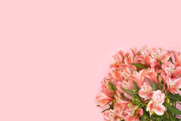 ピンクを背景にしたアロステミアの花の美しい花束。グリーティングカードのコンセプト。ウェディング花束スタイリッシュな花の組成。スペースのコピー - 写真・画像