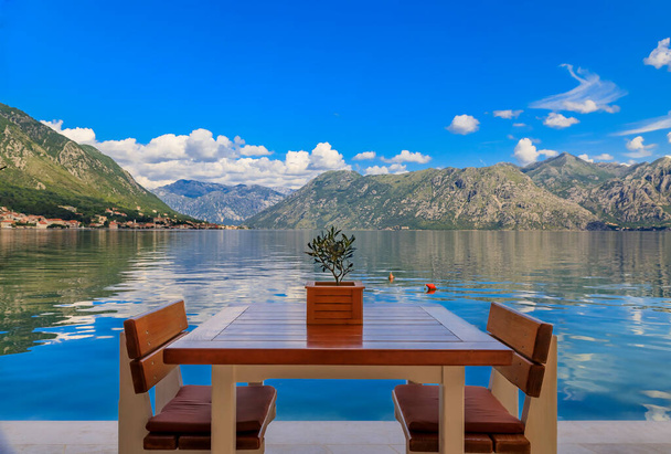 Nábřežní stůl v restauraci s výhledem na Kotor Bay of Kotor Bay nebo Boka Kotorska v pozadí v Černé Hoře, na Jaderském moři - Fotografie, Obrázek