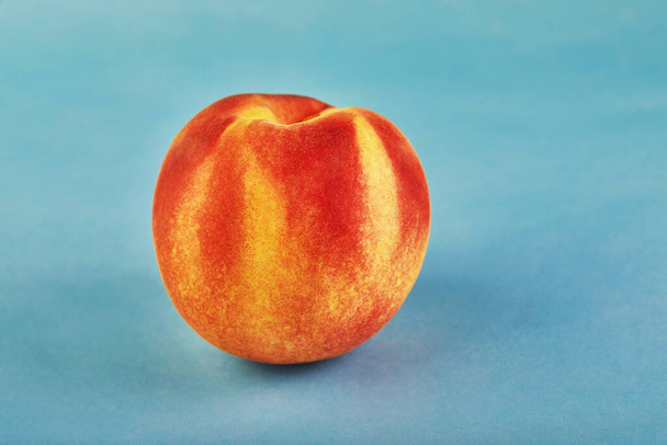Fresh juicy peach isolated on a blue background. - Photo, Image