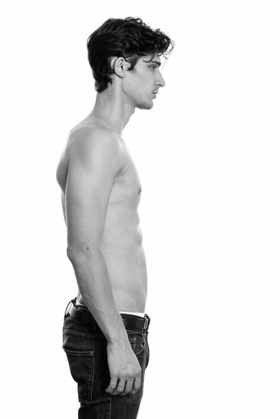 Studio záběr mladého pohledného brazilského muže izolované proti bílému pozadí v černé a bílé - Fotografie, Obrázek