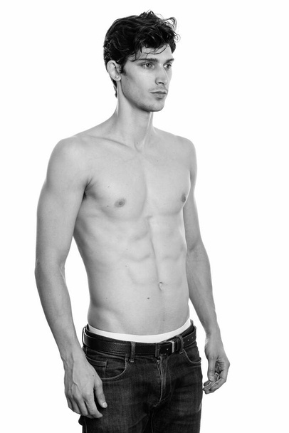 Estudio de un joven guapo brasileño aislado sobre fondo blanco en blanco y negro - Foto, imagen