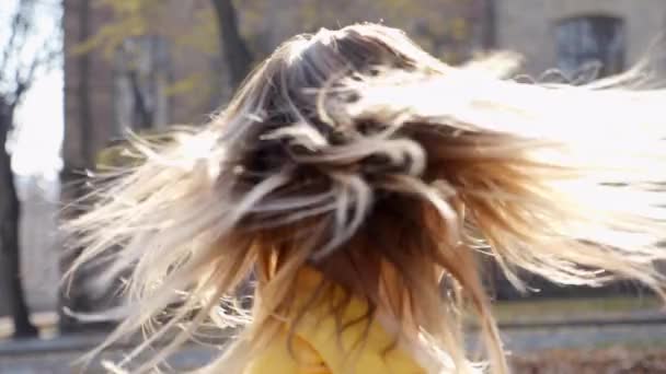 Dudaklarında pembe ruj olan kadın sonbahar parkında başını sallıyor. - Video, Çekim