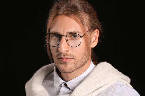 Jóképű férfi elegáns frizura sötét háttér - Fotó, kép