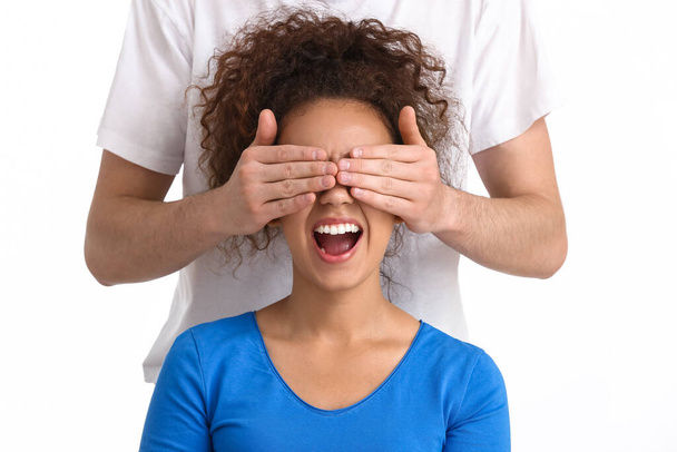 Mies peittää afroamerikkalaisen naisen silmät valkoisella taustalla. Lopeta rasismi - Valokuva, kuva