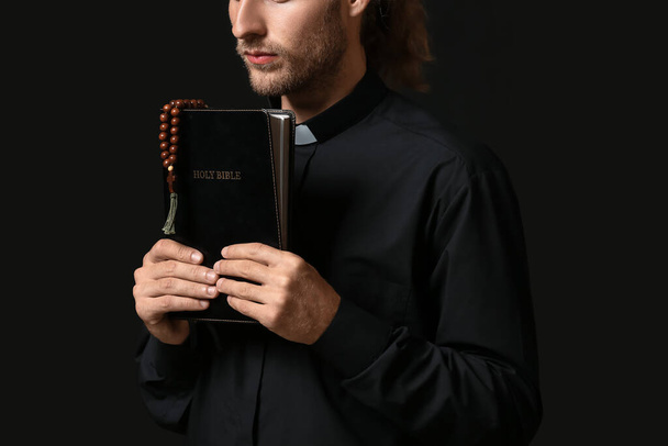 Esmer arka planda İncil 'i olan yakışıklı rahip. - Fotoğraf, Görsel