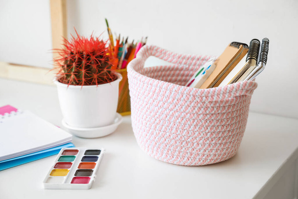 Wicker basket with painting supplies in room - Photo, Image