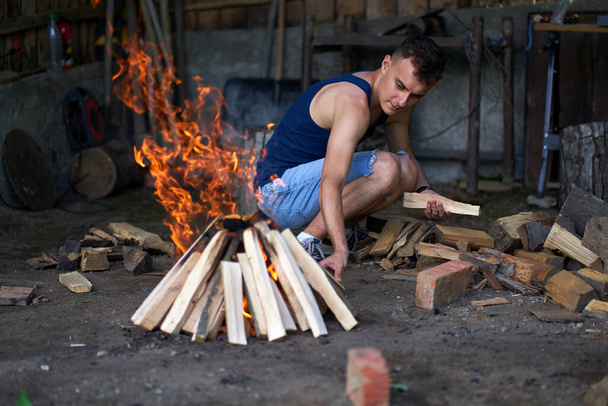 Young man preparing a fire for the barbecue - Foto, imagen